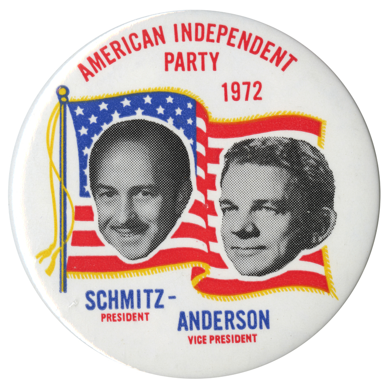 Round, white button with black and white portraits of John Schmitz and Thomas Anderson against a red, white, blue, and gold drawing of the US flag. Red and blue text reads "AMERICAN INDEPENDENT PARTY 1972 SCHMITZ - PRESIDENT ANDERSON - VICE PRESIDENT"