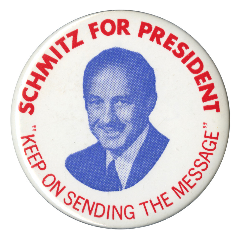 Round, white button with a blue portrait of John Schmitz and red text around the edge reading "SCHMITZ FOR PRESIDENT "KEEP ON SENDING THE MESSAGE""