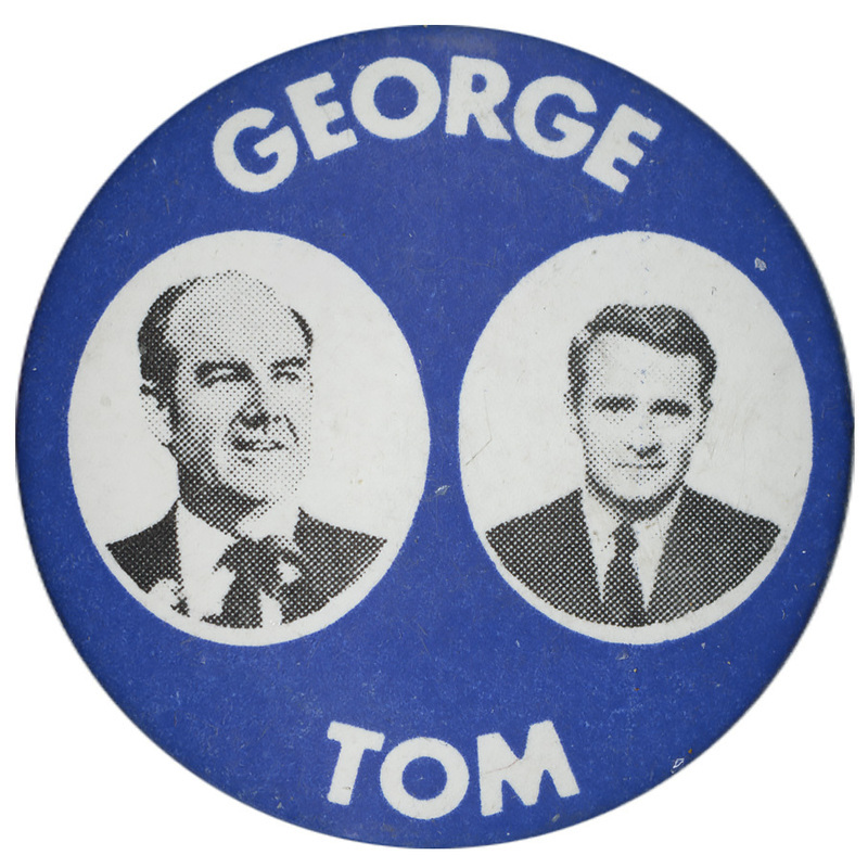 Round, blue text with black and white portraits of George McGovern and Thomas Eagleton in white circles. White text reads "GEORGE TOM"