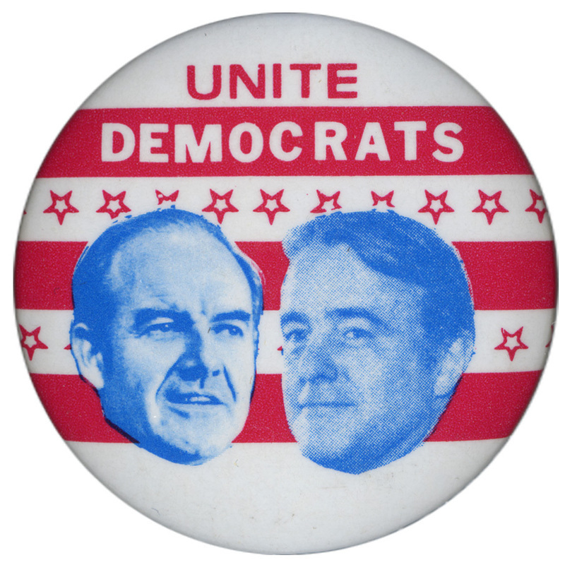 Round, red and white button with red stars and blue portraits of George McGovern and Thomas Eagleton. Red and white text reads "UNITE DEMOCRATS"