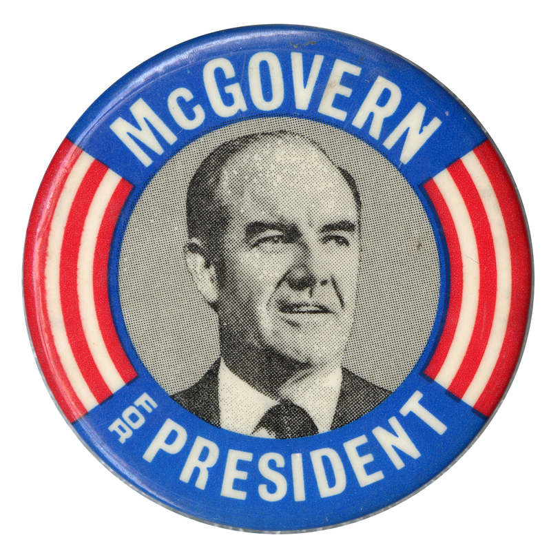 Round button with blue bands and red and white stripes surrounding a black and white portrait of George McGovern. White text reads "McGOVERN FOR PRESIDENT"