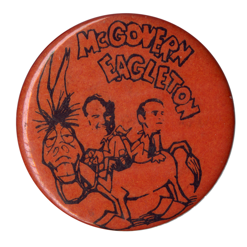 Round, red button with a cartoon drawing of George McGovern and Thomas Eagleton riding a donkey. Blocky, black text reads "McGOVERN EAGLETON"