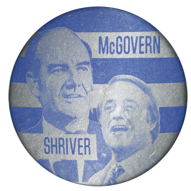 Round, blue and silver button with portraits of George McGovern and Sargent Shriver. Blue text reads "McGOVERN SHRIVER"