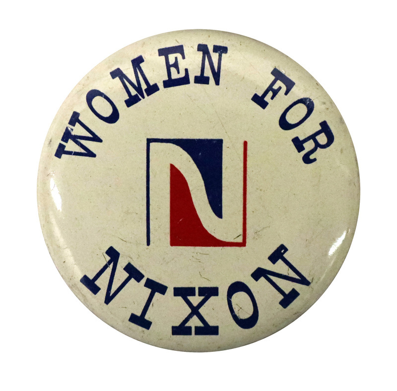 Round, white button with a stylized "N" in the center. Blue text reads "WOMEN FOR NIXON"