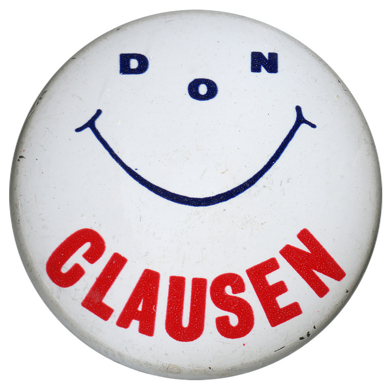Round, white button with a black smiley face. The eyes and nose of the face are the letters "DON". At the bottom of the button, red text reads "CLAUSEN"