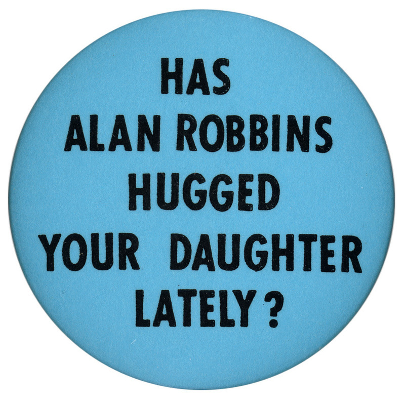 Round, blue button with black text reading "HAS ALAN ROBBINS HUGGED YOUR DAUGHTER LATELY?"