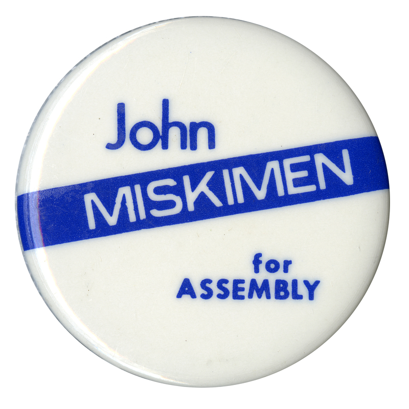 Round, white button with a blue band and blue and white text reading "John MISKIMEN for ASSEMBLY"