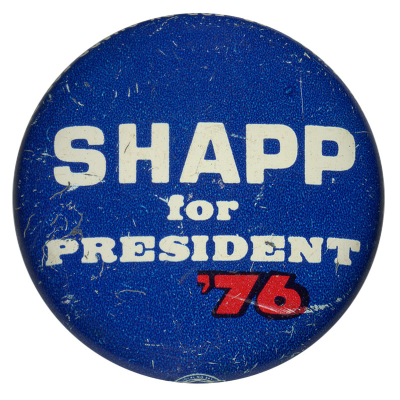 Round, blue button with white and red text reading "SHAPP for PRESIDENT '76"
