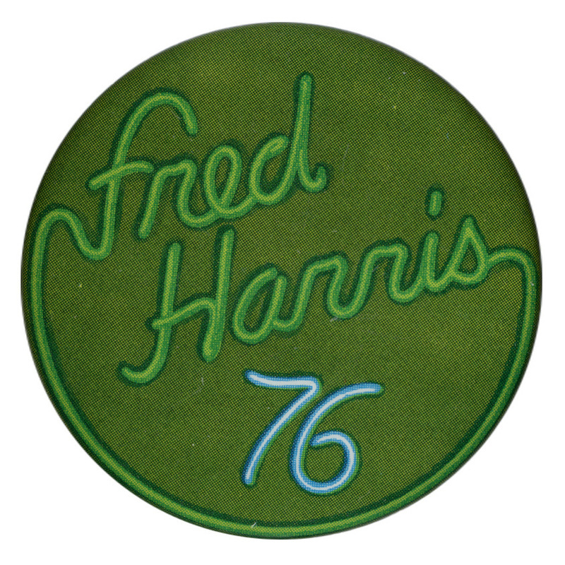 Round, green button with green and blue text in the style of a neon sign reading "Fred Harris 76"