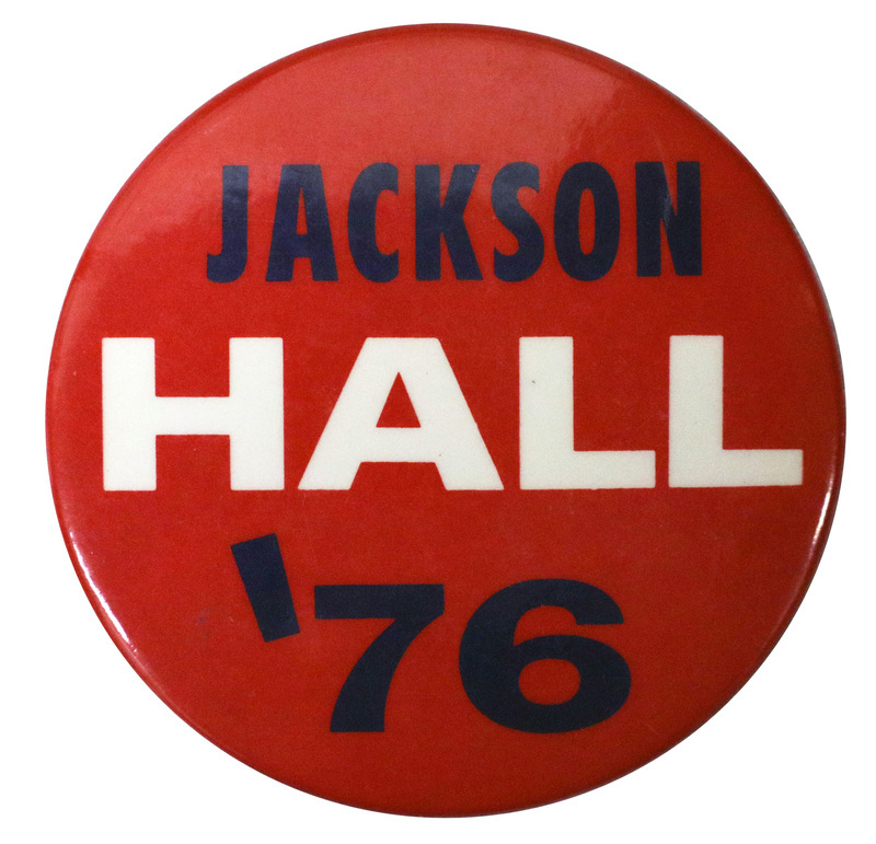 Round, red button with blue and white text reading "JACKSON HALL '76"