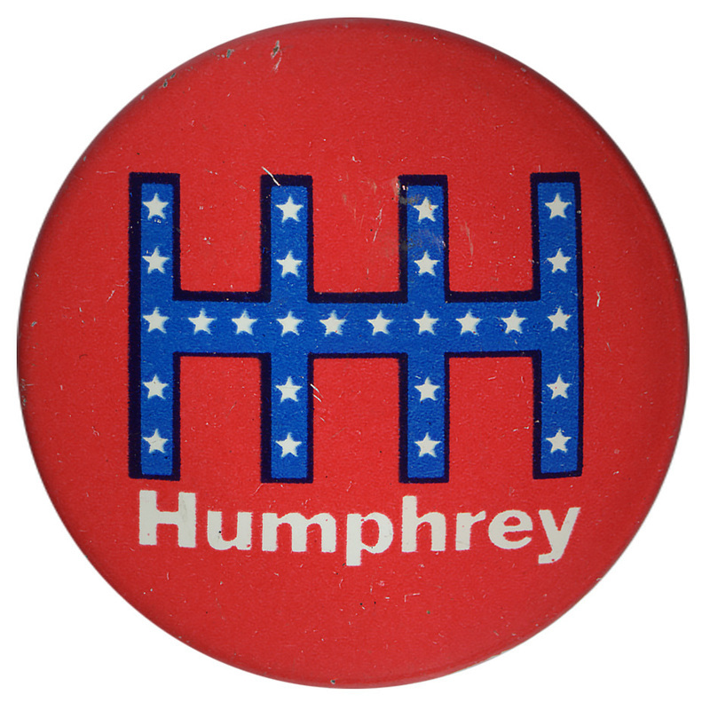 Round, red button with a stylized "HHH" in blue with white stars. White text reads "Humphrey"