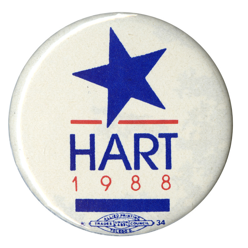 Round, white button with a large blue star. Blue and red text reads "HART 1988"