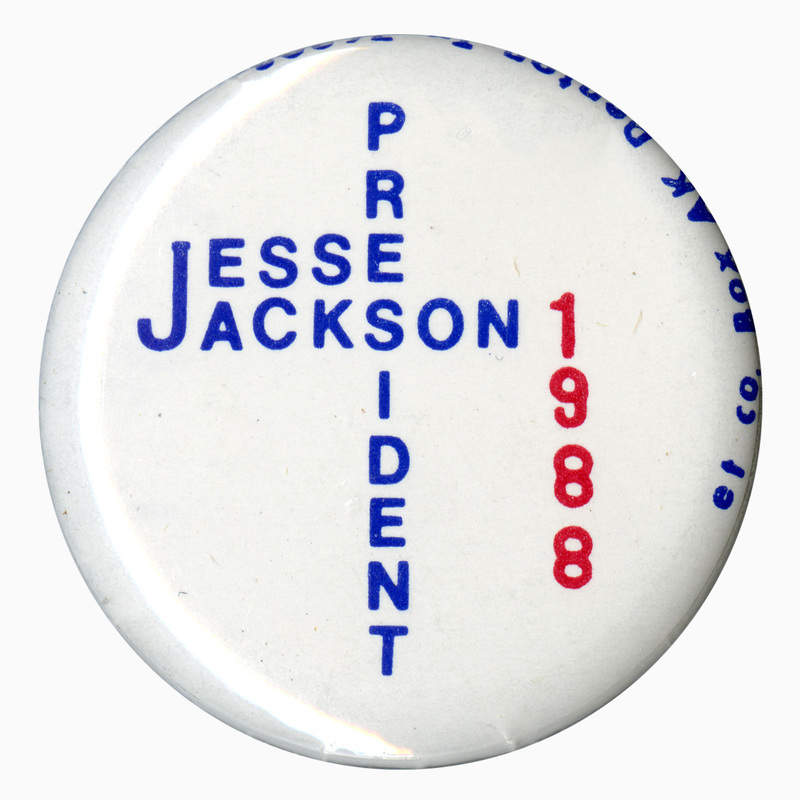 Round, white button with blue and red text reading "JESSE JACKSON PRESIDENT 1988"