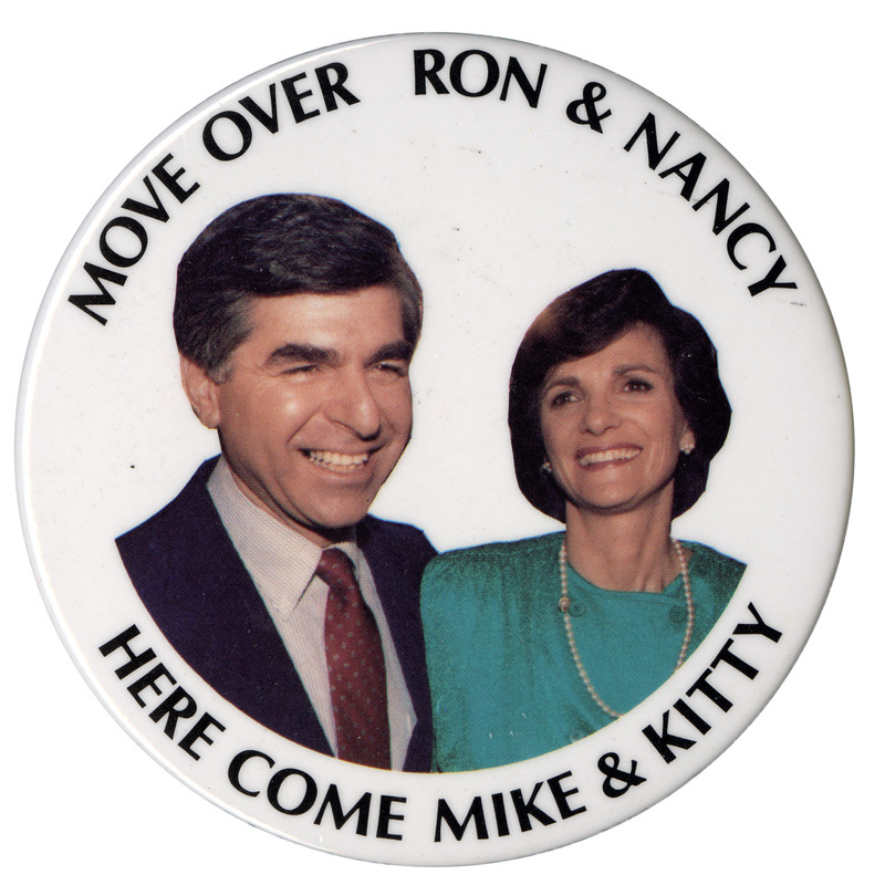 Round, white button with a color photograph of Michael Dukakis and Kitty Dukakis. Black text reads "MOVE OVER RON & NANCY HERE COME MIKE & KITTY"