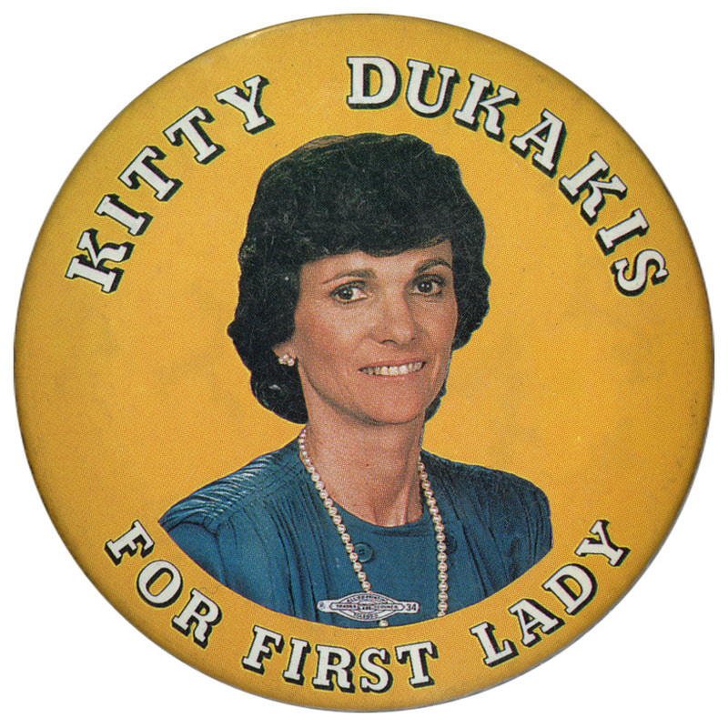 Round, gold button with a color photograph of Kitty Dukakis. White text reads "KITTY DUKAKIS FOR FIRST LADY"