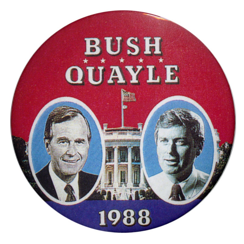 Round, red button with black and white photographs of George H. W. Bush and Dan Quayle against a photograph of the White House. White text reads "BUSH QUAYLE 1988"