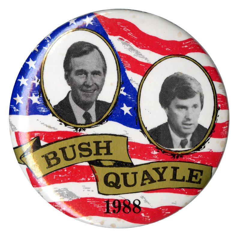 Round button with a red, white, and blue US flag background and black and white photograph of George H. W. Bush and Dan Quayle. Black text reads "BUSH QUAYLE 1988"