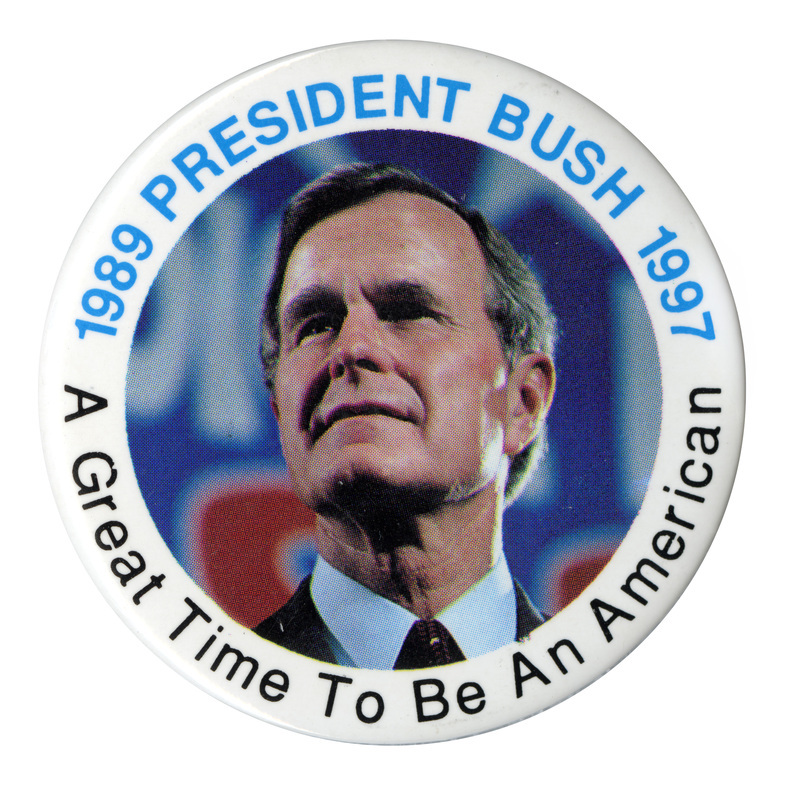 Round button with a white border and a color photograph of George H. W. Bush in the middle. Blue and black text around the edge reads "1989 PRESIDENT BUSH 1997 A Great Time To Be An American"