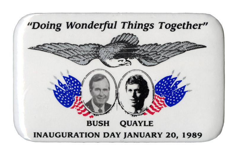 Rectangular, white button with black and white photographs of George H. W. Bush and Dan Quayle, each with his last name below his photograph, surrounded by US flags and an eagle drawing. Black text reads ""Doing Wonderful Things Together" INAUGURATION DAY JANUARY 20, 1989"