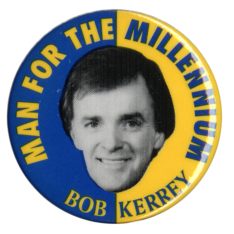 Round, blue and yellow button with a black and white photograph of Bob Kerrey. Contrastic yellow and blue text reads "MAN FOR THE MILLENNIUM BOB KERREY"
