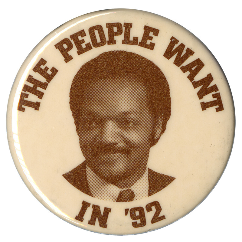 Round, white button with a black and white photograph of Jesse Jackson. Black text reads "THE PEOPLE WANT IN '92"
