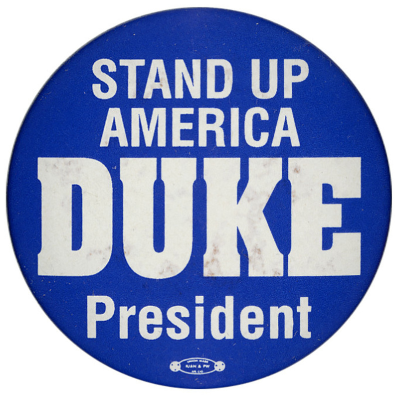 Round, blue button with white text reading "STAND UP AMERICA DUKE President"