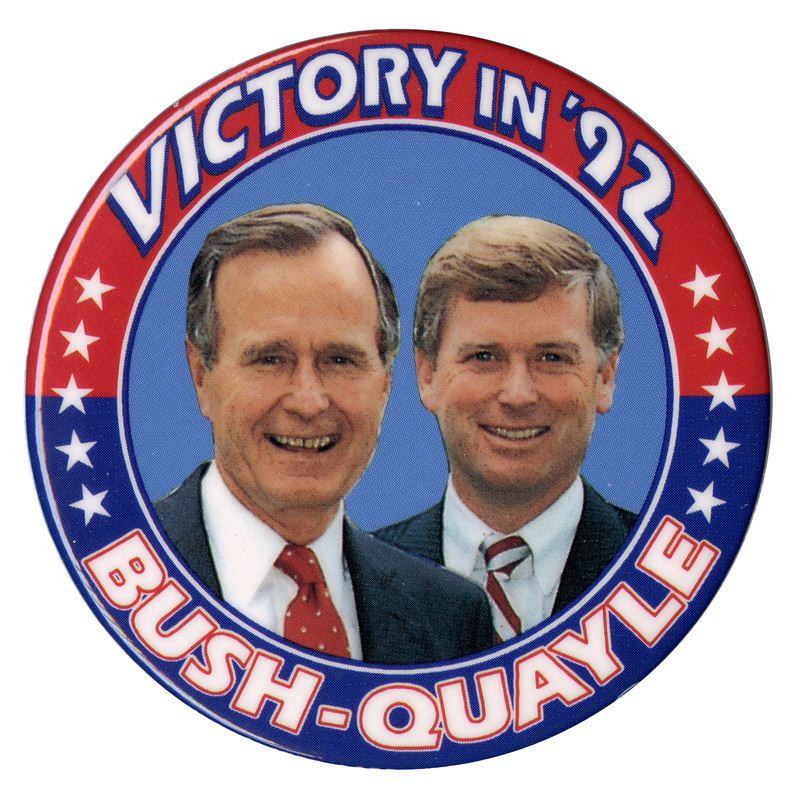 Round button with a red and blue border and color photographs of George H. W. Bush and Dan Quayle in the center. White text around the edge of the button reads "VICTORY IN '92 BUSH-QUAYLE"