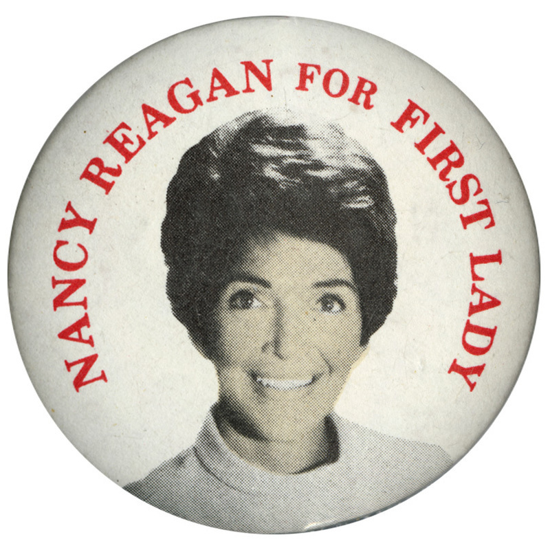 Round, white button with a color photograph of Nancy Reagan and red text reading "NANCY REAGAN FOR FIRST LADY"