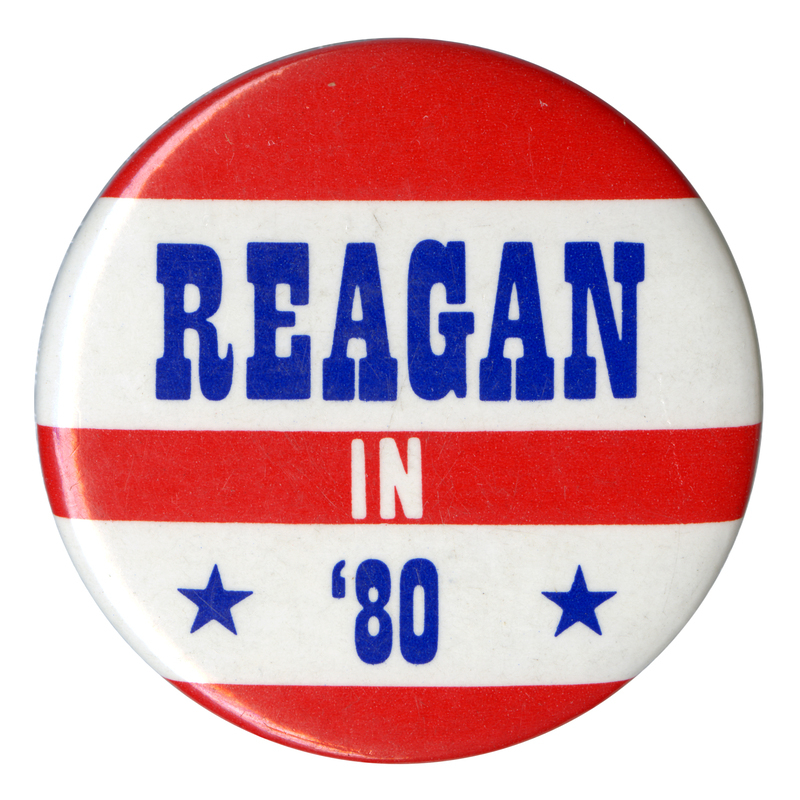 Round button with red and white stripes. Blue and white text reads "REAGAN IN '80"