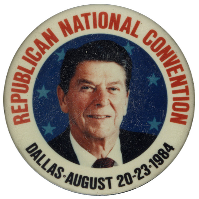 Round button with a white border and a color photograph of Ronald Reagan. Red and blue text reads "REPUBLICAN NATIONAL CONVENTION DALLAS AUGUST 20-23 1984"