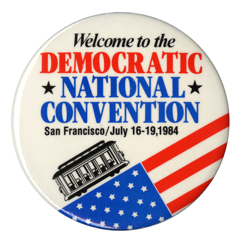 Round, white button with a drawing of a black trolley ascending an angled US flag. Black, red, and blue text reads "Welcome to the DEMOCRATIC NATIONAL CONVENTION San Francisco/July 16-19, 1984"