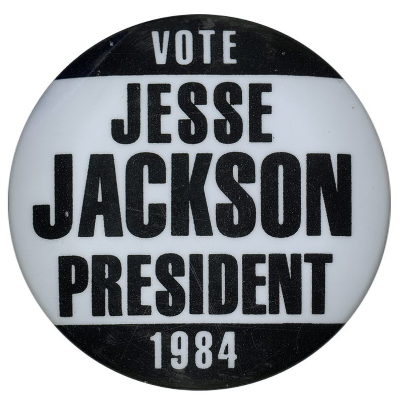 Round, black and white button with contrasting white and black text reading "VOTE JESSE JACKSON PRESIDENT 1984"