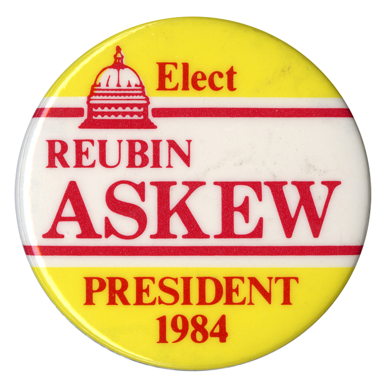 Round, yellow and white button with a red drawing of the US Capitol dome. Red text reads "Elect REUBIN ASKEW PRESIDENT 1984"