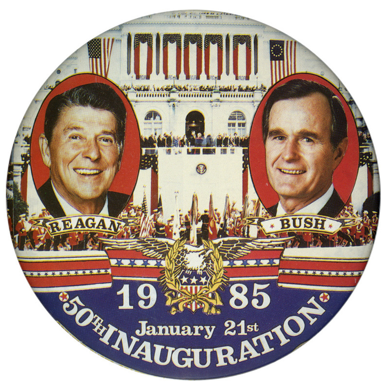Round button with color photographs of Ronald Reagan and George H. W. Bush against a color photograph of the US Capitol. On the lower part of the button is an elaborate decoration with an eagle,  and scrollwork. White text reads "1985 January 21st 50th INAUGURATION"
