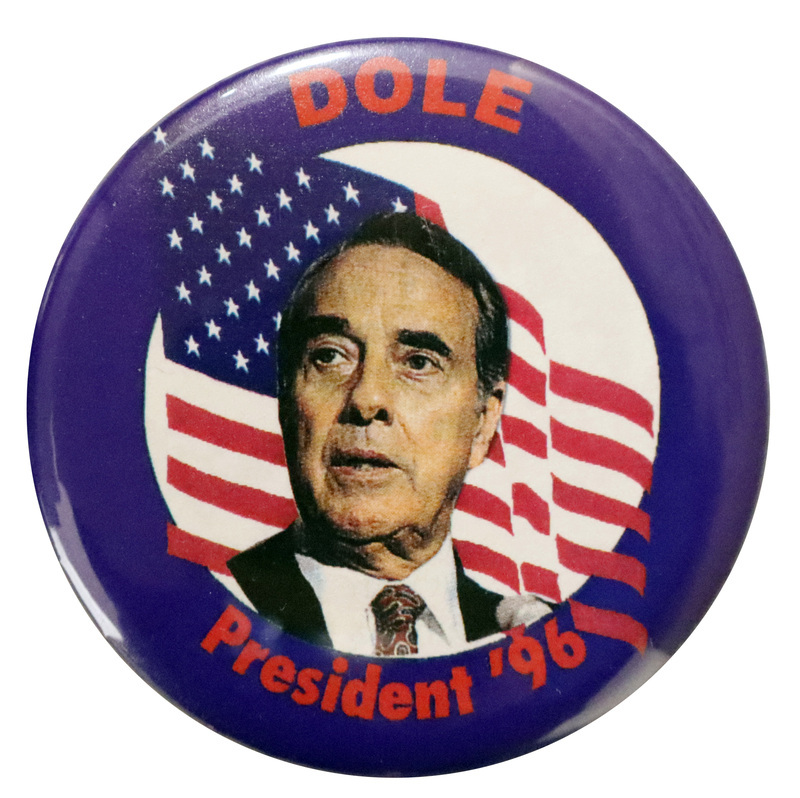 Round, blue button with a color photograph of Bob Dole against an illustration of the US flag. Red text reads "DOLE President '96"