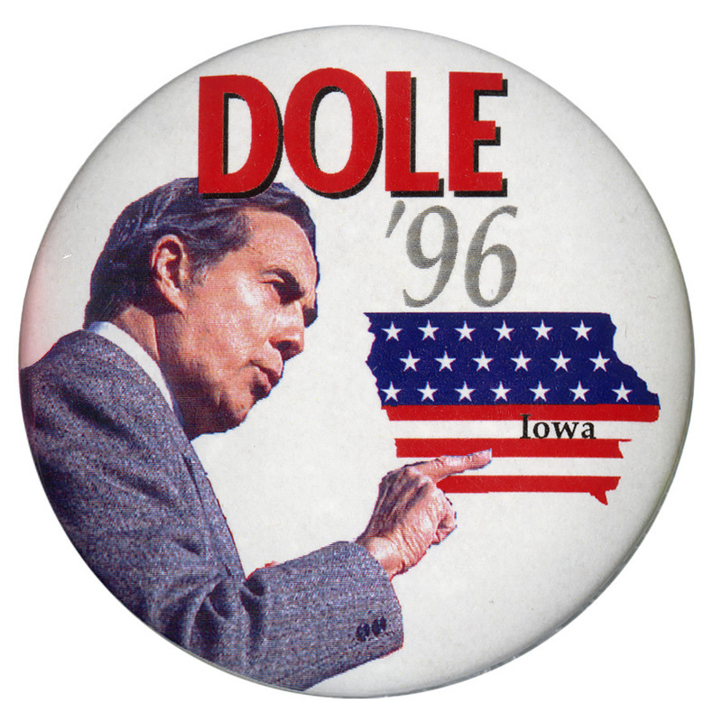 Round, white button with a color photograph of Bob Dole and an outline of the state of Iowa filled in with US flag stars and stripes. Red and gray text reads "DOLE '96". Iowa is labeled "Iowa". 
