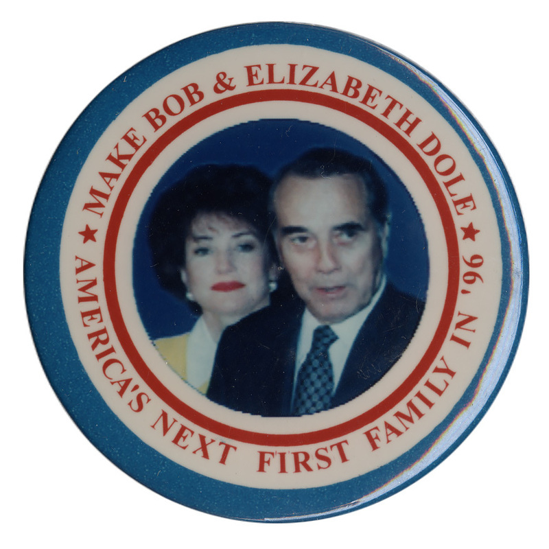 Round button with nested blue, white, and red borders. In the center is a color photograph of Elizabeth and Bob Dole. Red text reads "MAKE BOB & ELIZABETH DOLE AMERICA'S NEXT FIRST FAMILY IN '96"