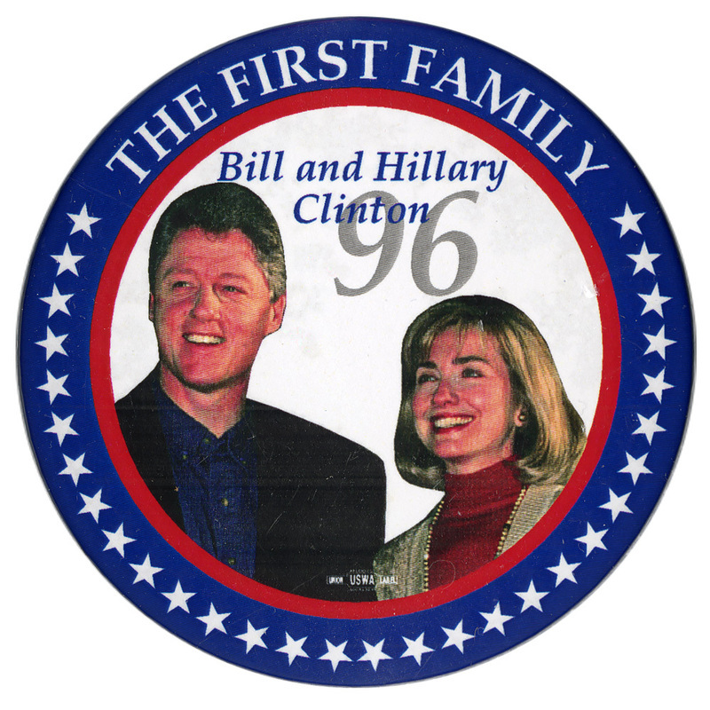 Round button with a red and blue border with white stars. In the center is a color photograph of Bill Clinton and Hillary Clinton. White, blue, and gray text reads "THE FIRST FAMILY Bill and Hillary Clinton 96"