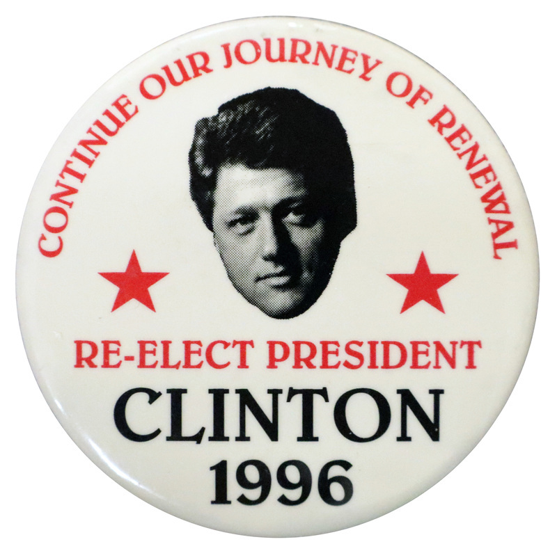 Round, white button with a black and white photograph of Bill Clinton's head between two red stars. Red and black text reads "CONTINUE OUR JOURNEY OF RENEWAL RE-ELECT PRESIDENT CLINTON 1996"