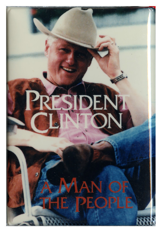 Rectangular button with a color photograph of Bill Clinton wearing a cowboy hat. White and red text reads "PRESIDENT CLINTON A MAN OF THE PEOPLE"