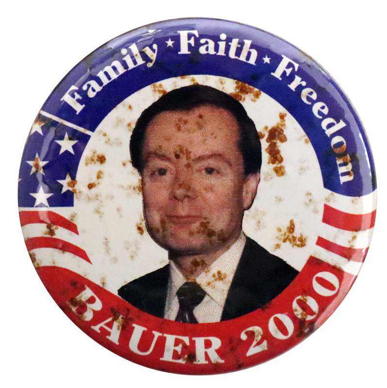 Round button with a border of red, white, and blue stars and stripes. In the center is a color photograph of Gary Bauer. White text reads "Family Faith Freedom BAUER 2000"