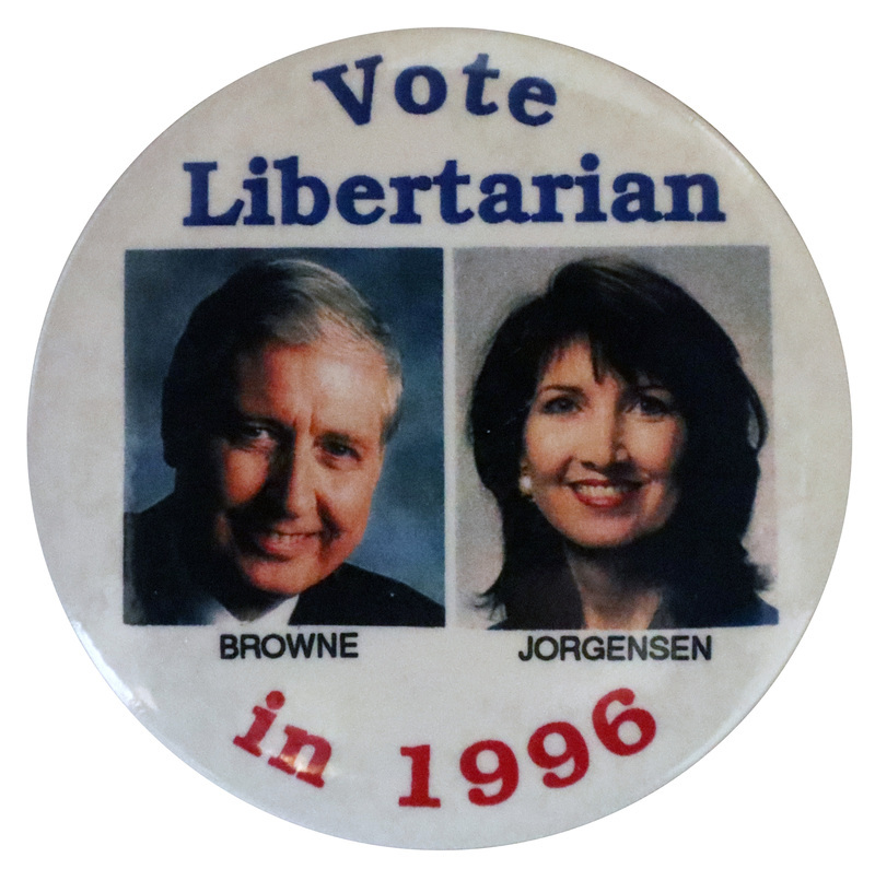 Round, white button with color photographs of Harry Browne and Jo Jorgensen, each with their last name underneath their photo. Blue and red text reads "Vote Libertarian in 1996"