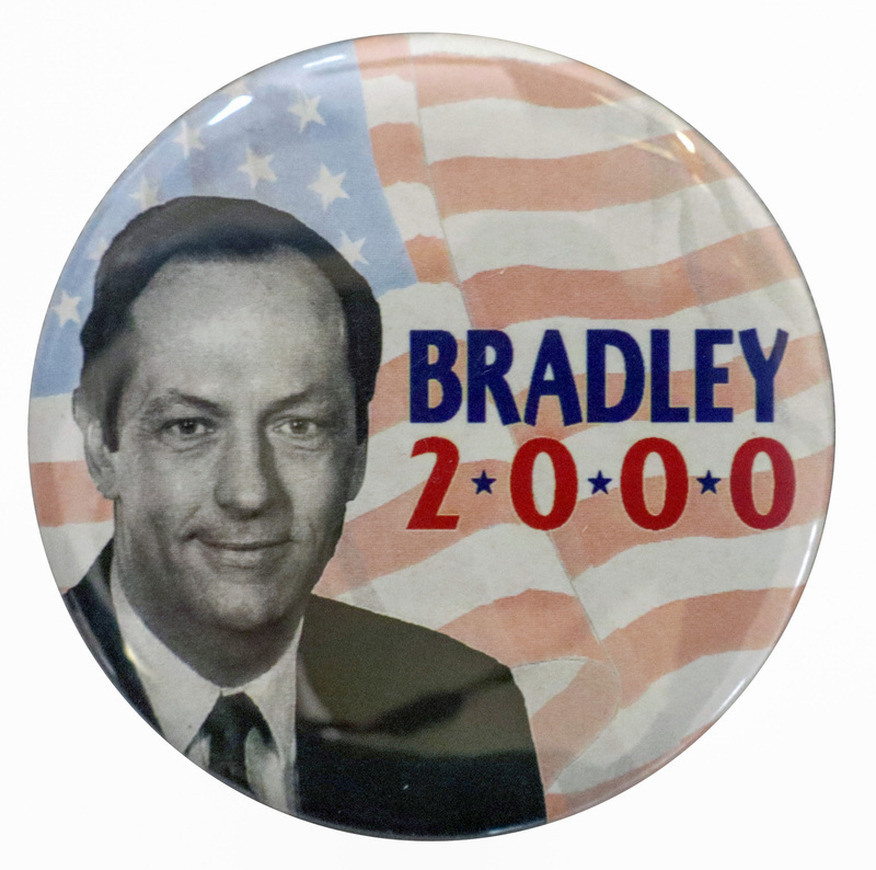 Round button with a black and white photograph of Bill Bradley against a color illustration of the US flag. Blue and red text reads "BRADLEY 2000"