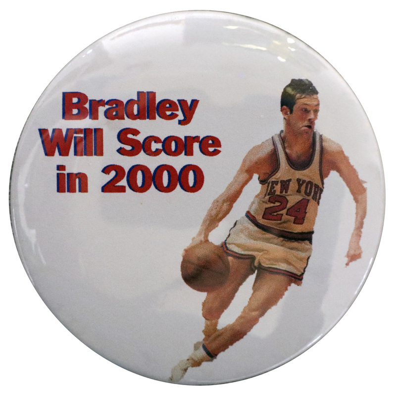Round, white button with a color photograph of Bill Bradley playing basketball. Red text reads "Bradley Will Score in 2000"