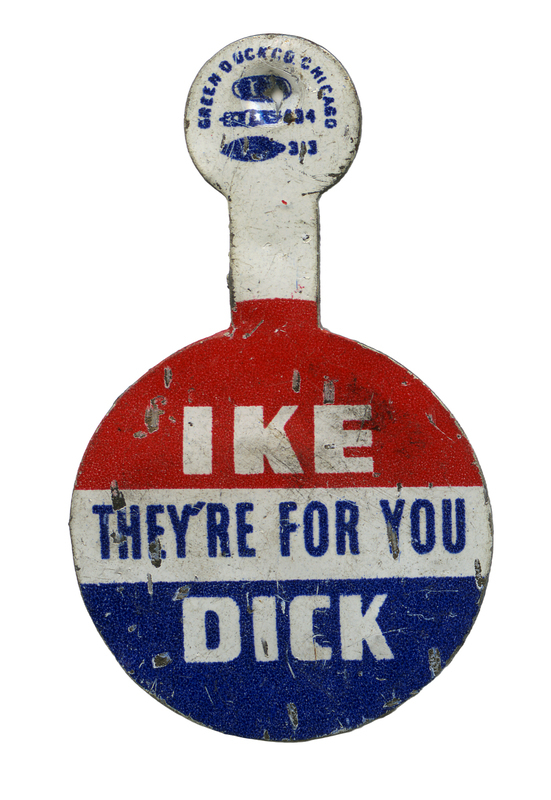 Round lapel pin with a horizontal blocks of red, white, and blue. White and blue text reads "IKE DICK THEY'RE FOR YOU."
