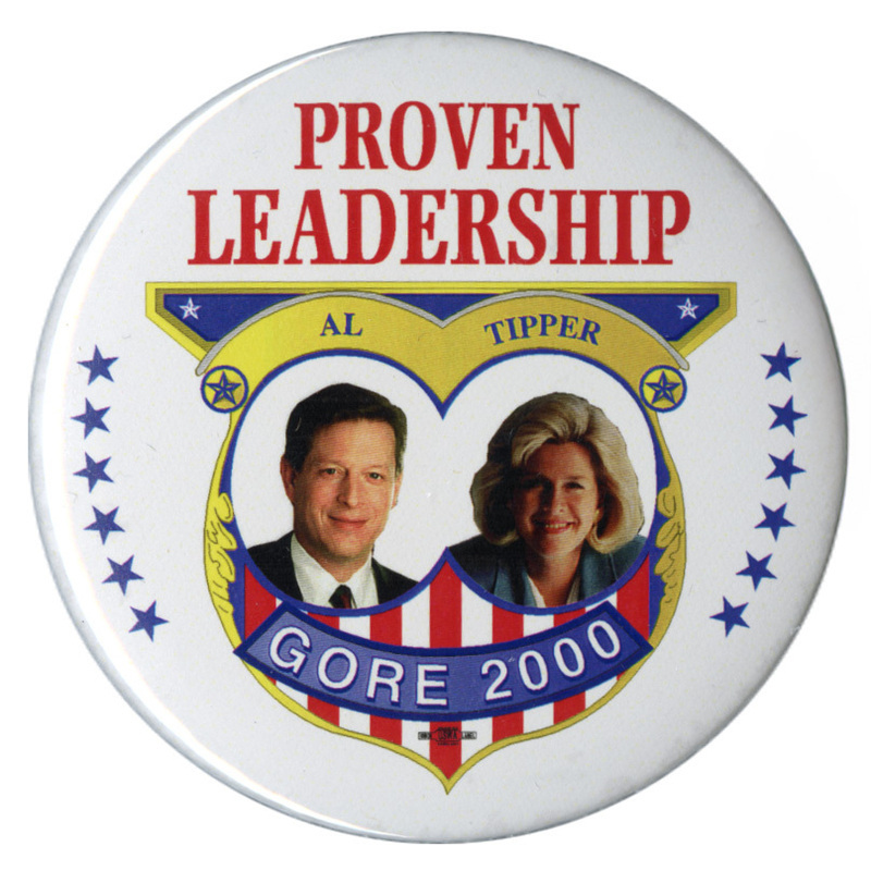 Round, white button with color photographs of Al and Tipper Gore in an elaborate gold, red, and blue frame. Red, blue, and white text reads "PROVEN LEADERSHIP Al TIPPER GORE 2000"