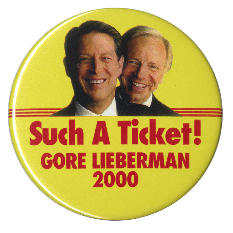 Round, yellow button with color photographs of Al Gore and Joe Lieberman. Red text reads "Such a Ticket! GORE LIEBERMAN 2000"