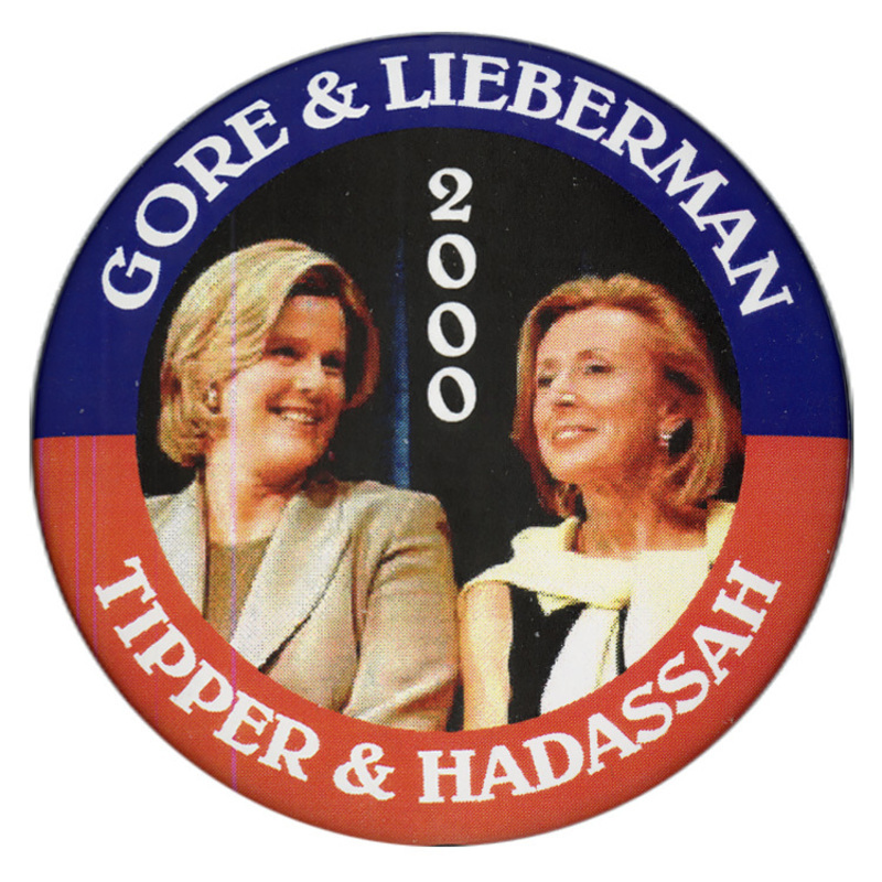 Round text with a blue and red border. In the center is a color photograph of Tipper Gore and Hadassah Lieberman. White text reads "GORE & LIEBERMAN 2000 TIPPER & HADASSAH"