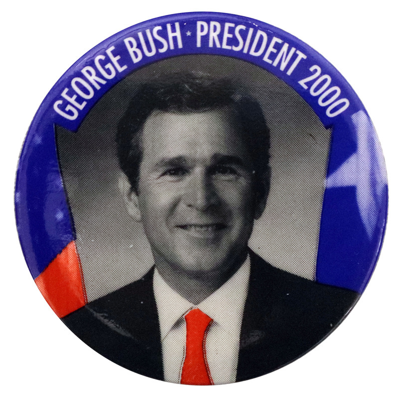 Round button with a black and white photograph of George W. Bush, his tie colored in red. A blue and red border contains white text reading "GEORGE BUSH PRESIDENT 2000"