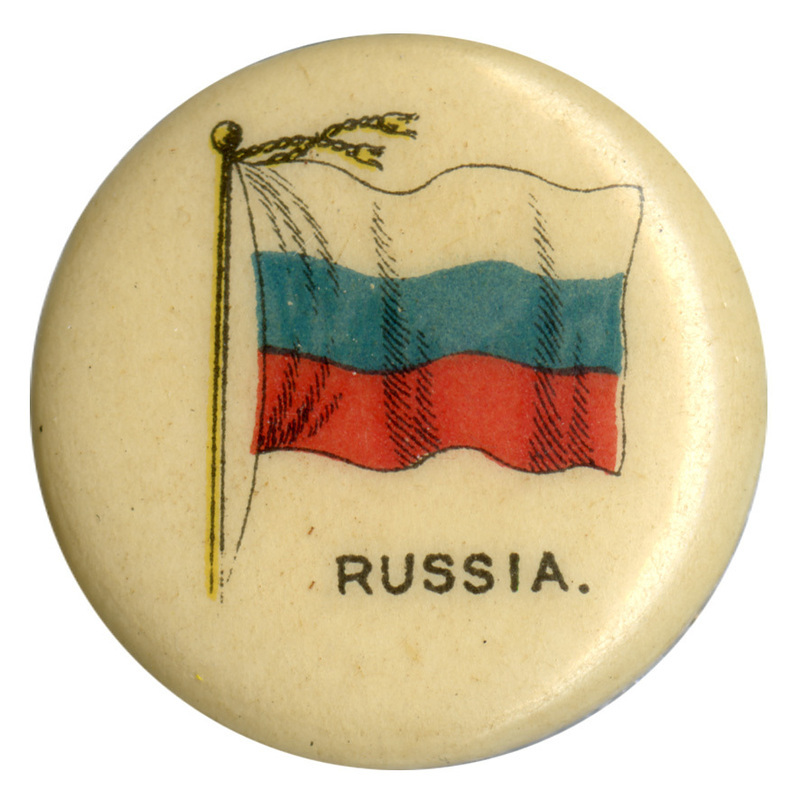 Round, white button with a color illustration of the flag of Russia, horizontal white, blue, and red bands. Black text at the bottom reads "RUSSIA."